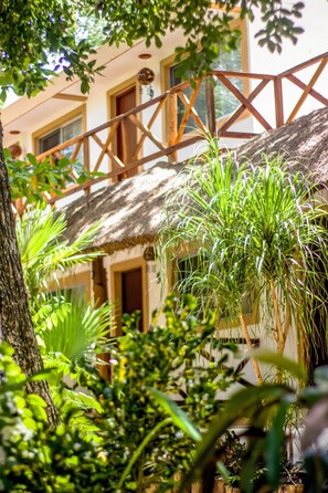 A building with a thatched roof and wooden balcony.