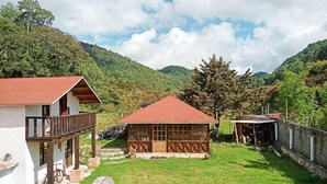 A rustic building with a red roof, a balcony, and a wooden fence. - Calkiní Cabañas (San Cristóbal de las Casas)