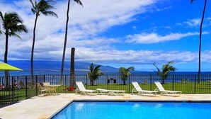 Une piscine avec des chaises longues et vue sur l’océan.