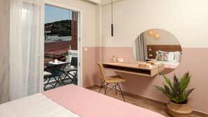 A bedroom with a bed, a desk, a chair, a mirror, and a potted plant. - Salty Colours Apartments (Apokoronas)