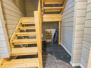 A wooden staircase leading to a loft area with a chair and a suitcase. - Uulanlinna a, paritalo by Interhome (Hyrynsalmi)