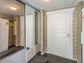 A room with a white door, a sliding glass door, and a white refrigerator. - Uulanlinna a, paritalo by Interhome (Hyrynsalmi)