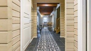 A hallway with patterned carpet, wooden benches, and a staircase. - Uulanlinna a, paritalo by Interhome (Hyrynsalmi)