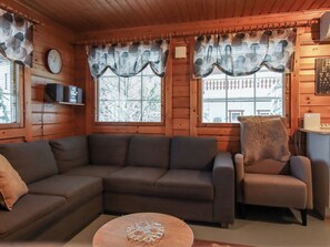A cozy living room with a sectional sofa, a chair, and a small table.