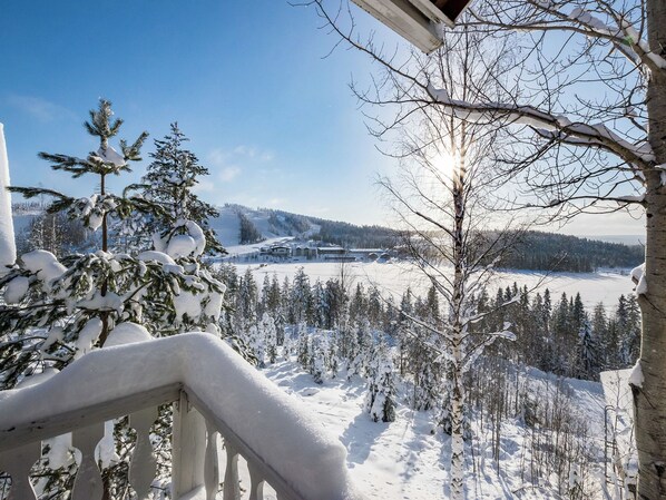 A snow-covered landscape with a view of a building and trees.