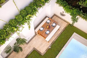 Vue aérienne d’une terrasse avec une table à manger, des chaises et une piscine.