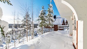 A snow-covered landscape with a building featuring a white facade and a visible window. - Alppikylä 13b by Interhome (Hyrynsalmi)