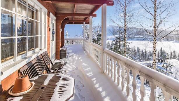 A wooden balcony with a view of a snowy landscape. - Aurinkoalppi 10a by Interhome (Hyrynsalmi)