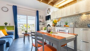 A modern kitchen with wooden cabinets, a granite countertop, and a dining area with a table and chairs. - Wonderful  villa for 6 guests with A/C, pool, WIFI, TV, patio and pets allowed (Deltebre)