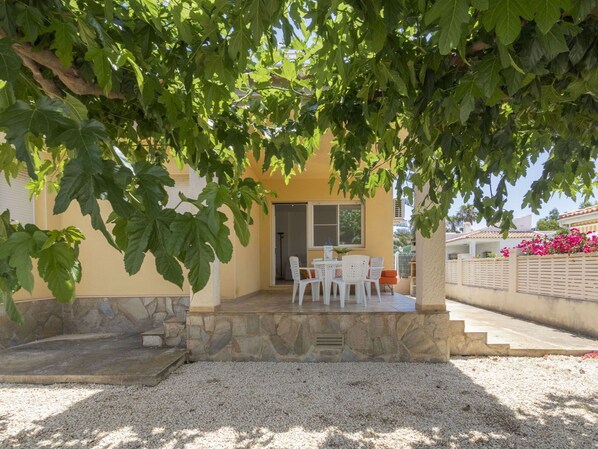A house with a stone patio, white outdoor furniture, and a view of the surrounding area. - Stunning private villa for 5 guests with A/C, WIFI, TV, patio and pets allowed (Deltebre)
