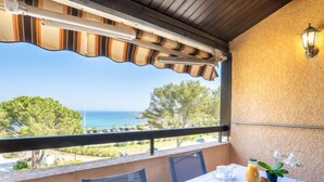 A balcony with a table set for breakfast, overlooking a coastal view. - La Gaillarde by Interhome (Les Issambres)