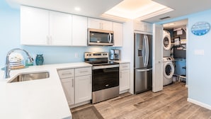 A modern kitchen with white cabinets, stainless steel appliances, and a built-in oven. - Upscale Sea Winds 8th Floor Beachfront Weekly Rental (Marco Island)