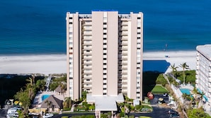 A high-rise hotel with multiple floors, a swimming pool, and a beach view. - Upscale Sea Winds 8th Floor Beachfront Weekly Rental (Marco Island)