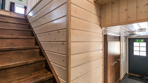 A wooden staircase leading to a room with a door and a window. - Hallan karhu c, paritalo by Interhome (Hyrynsalmi)