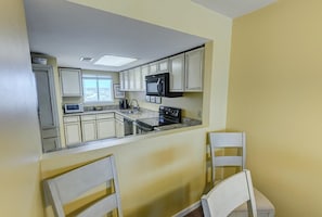 Enjoy meals in this cozy kitchen with a black stove and dining area.