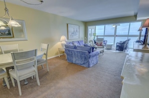 Relax in this inviting living room with a view, featuring a sofa, dining table, and lamp.