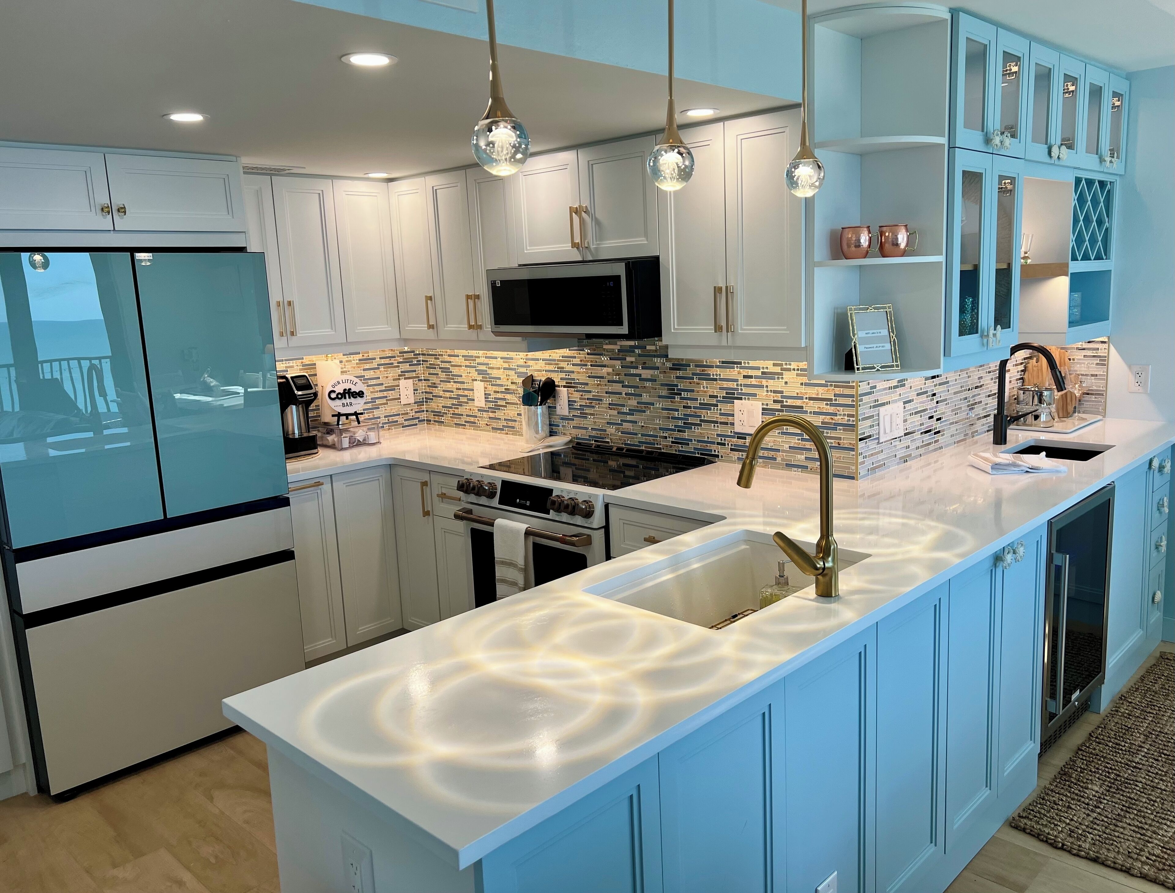 A modern kitchen with a central island, white cabinets, a microwave, and a built-in oven.