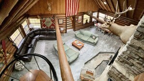 Interieur van een blokhut met een vide, een grote Amerikaanse vlag, een hertenkop en een opgezette eland.