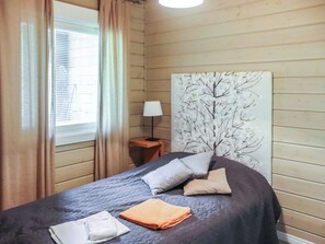 A bedroom with a bed, a nightstand, a lamp, and a wall art piece. - Uulanlinna b, paritalo by Interhome (Hyrynsalmi)