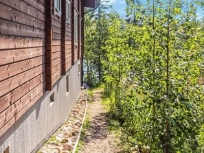 A wooden building with a gravel path leading to a green area with trees. - Uulanlinna b, paritalo by Interhome (Hyrynsalmi)