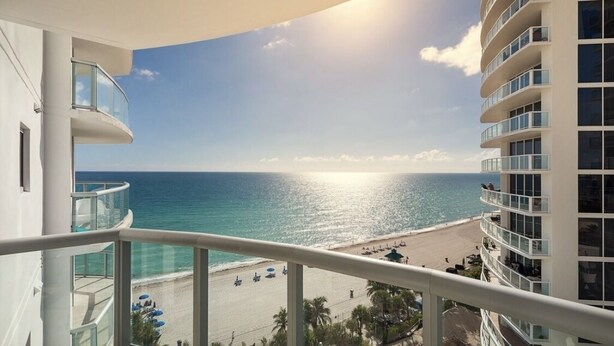A balcony with a view of a beach and ocean. - Marenas Ocean View Apartment (Sunny Isles Beach)