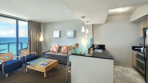 A modern hotel room with a balcony, a dining area, a sofa, and a kitchen. - Marenas Ocean View Apartment (Sunny Isles Beach)