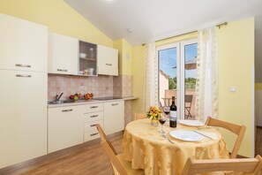 Une cuisine équipée d’une table à manger pour deux personnes, d’un évier et de placards.