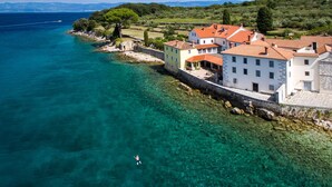 A coastal town with clear waters, a person swimming, and buildings with red roofs. - Pool Suite Glavotok at Krk Island, Krk, Croatia (Krk)