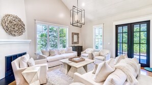 A spacious living room with a white sofa set, a coffee table, and a fireplace. - Luxury 2-Story Home | 2-min to pool | 8-min to the beach | 1-mile from Seaside (Seagrove Beach)