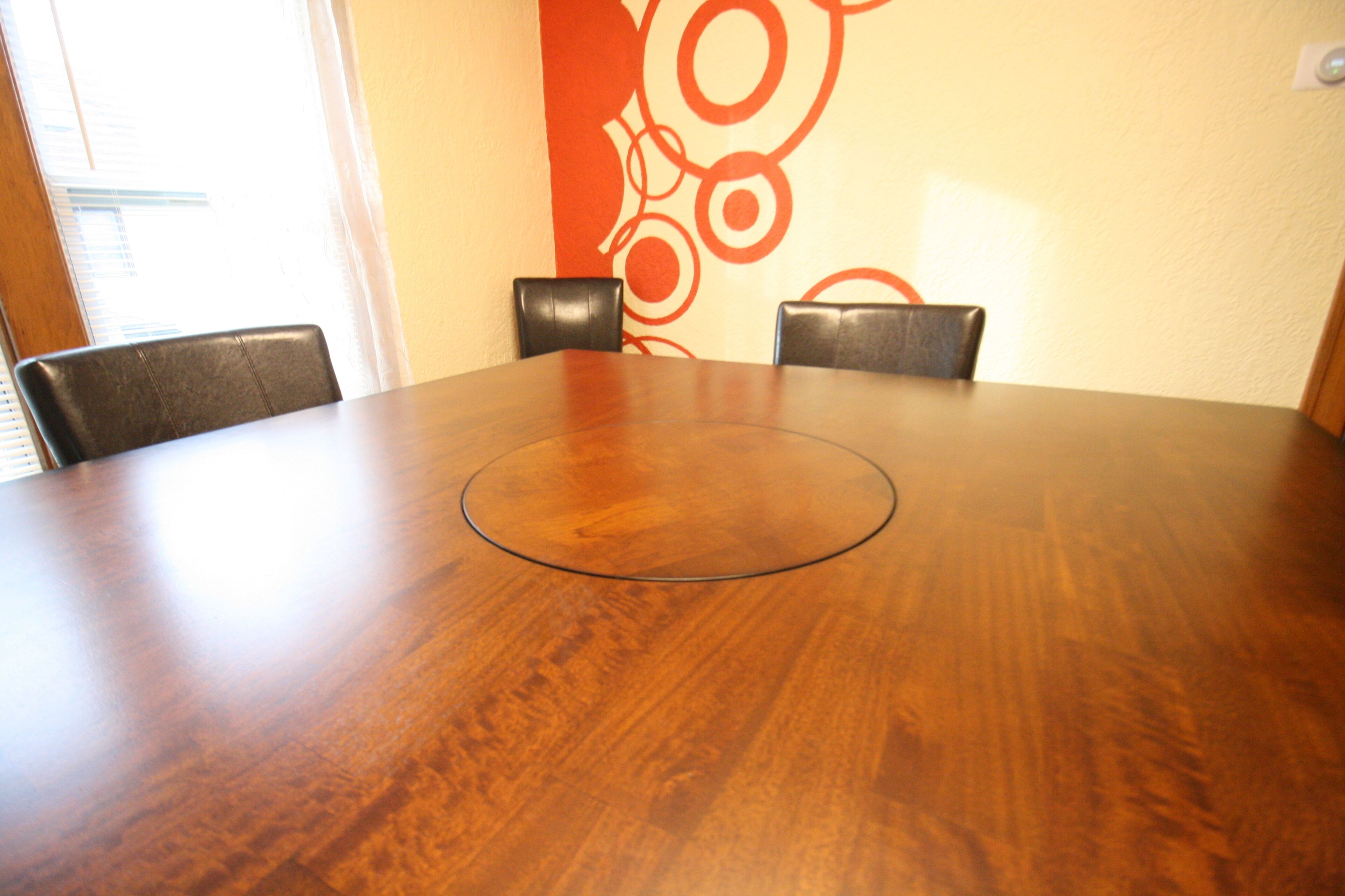 A conference table with a circular center, surrounded by four chairs.