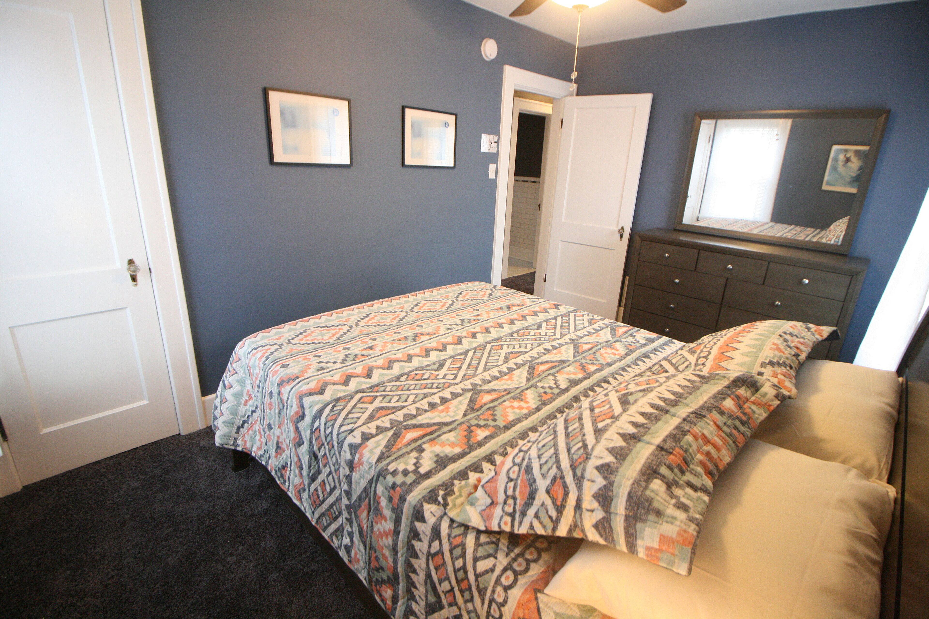 Un dormitorio con cama, cómoda y puerta.