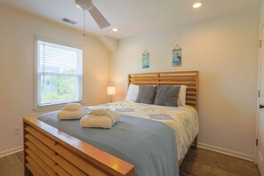 A bedroom with a bed, a bedside table, a window with blinds, a ceiling fan, and two wall-mounted light fixtures. - 2 Minute Walk to Beach!  Covered porch, outdoor shower, renovated kitchen & more! (Isle of Palms)