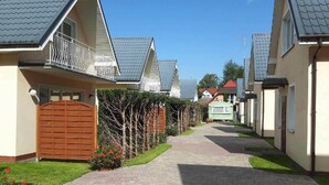 A residential street with houses featuring gabled roofs and a central pathway. - Large, comfortable holiday homes close to the sea (Niechorze)