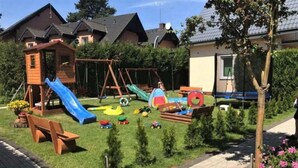 A playground with a slide, swings, and play structures. - Large, comfortable holiday homes close to the sea (Niechorze)