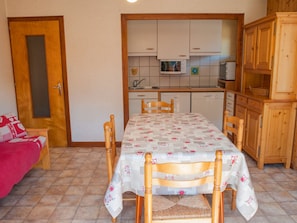 A compact kitchen with wooden cabinets, a microwave, and a dishwasher.