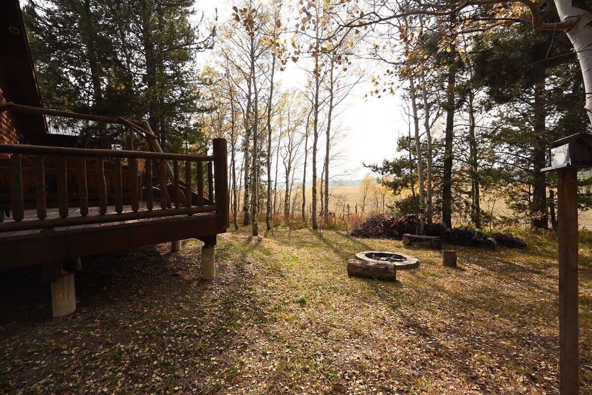 Un banc en bois, situé dans une zone boisée, avec un foyer et une structure en bois.
