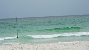 A beach with a fishing rod on the sand. - HOLIDAY INN EXPRESS & SUITES GULF BREEZE - PENSACOLA AREA by IHG (Gulf Breeze)