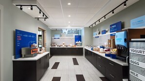 A modern kitchen with dark cabinets, a white countertop, and a refrigerator displaying yogurt, eggs, and milk. - HOLIDAY INN EXPRESS & SUITES GULF BREEZE - PENSACOLA AREA by IHG (Gulf Breeze)