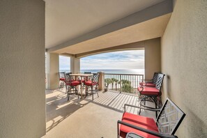 Enjoy ocean views from this balcony with outdoor dining space and comfortable seating.