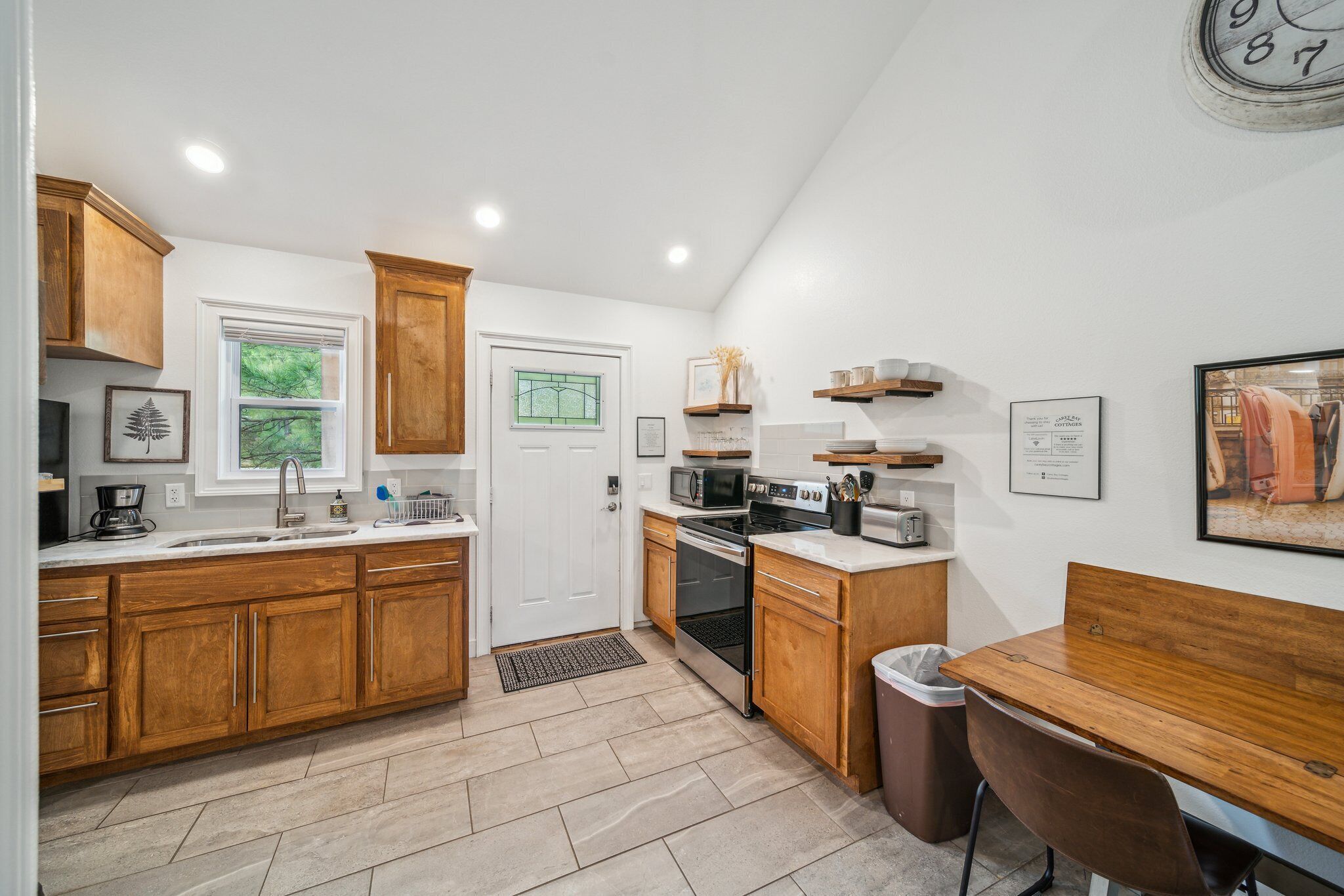 A modern kitchen with wooden cabinets, a microwave, stove, and a dining area with a table and chairs.