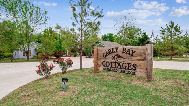 A wooden sign for Carey Bay Cottages with a website address.