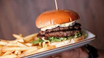 A person holding a plate with a burger and fries.