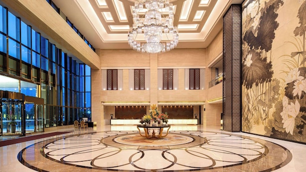 Un hall d’entrée spacieux, agrémenté d’un magnifique lustre, d’un comptoir de réception et d’une grande fresque florale.