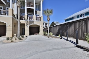 A multi-story hotel with a central entrance, balconies, and a gated driveway.