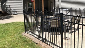Un patio cercado con mobiliario exterior y una zona de estar cubierta.
