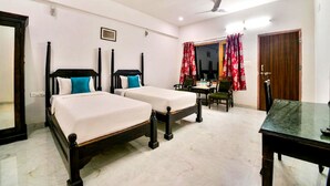 A room with two single beds, a dining table, and a chair. - The Sky Imperial Jungle Camp Resort (Kumbhalgarh)