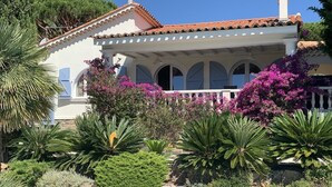 Uma villa em estilo mediterrâneo com telhado em azulejos, janelas em arco e parede de pedra.