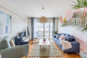 A modern living room with a sofa, coffee table, and a television.