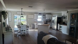 A modern kitchen with white cabinets, a central island, and stainless steel appliances.