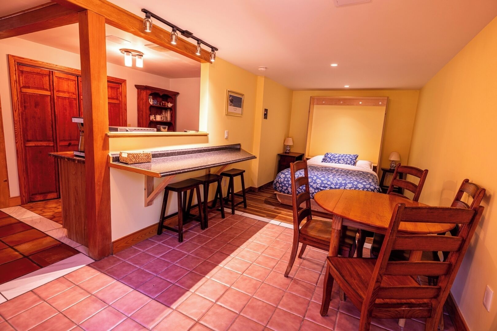 Une chambre d’hôtel compacte comprenant un coin cuisine, un espace repas et un lit.